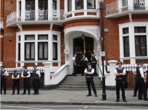 Policiais britânicos cercam a Embaixada do Equador em Londres, onde Assange está refugiado desde junho (Foto: Sang Tan/AP)